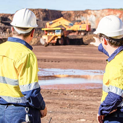 Two mining workers in high vis uniform on a mine site - mental health awareness eLearning training courses for mining and resources